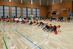 写真：コートの雑巾がけをする小学生たち