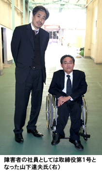 写真：障害者の社員としては取締役第１号となった山下達夫氏（右）