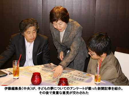 写真：伊藤編集長（中央）が、子どもの夢についてのアンケートが載った新聞記事を紹介。その後で貴重な意見が交わされた