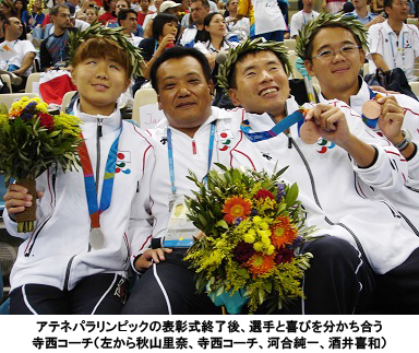 写真：アテネパラリンピックの表彰式終了後、選手と喜びを分かち合う寺西コーチ（左から秋山里奈、寺西コーチ、河合純一、酒井喜和）