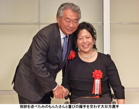 写真：祝辞を述べたみのもんたさんと喜びの握手を交わす大日方選手